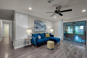 a living room with a blue couch and a ceiling fan at Quiet relaxing home - Close to Downtown & Beach 4BR-2BT in Pensacola