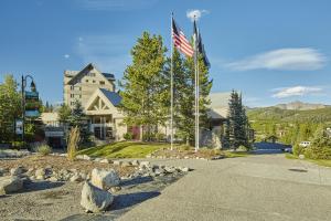 a house with two flags in front of a road at Shoshone 1905 in Big Sky