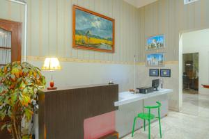 Kartika Syariah Guest House في سولو: غرفة انتظار مع منضدة وبار مع مقعد