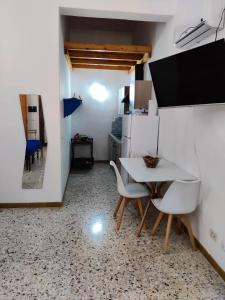 a kitchen with a table and chairs in a room at Il Giardino su Lido Burrone in Favignana