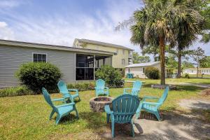 a group of blue chairs sitting around a fire pit at Pura Vida - A -Murrells Inlet in Myrtle Beach