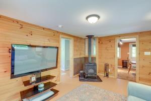 a living room with a flat screen tv and a wood wall at Secluded Marshall Cottage Hot Tub and Mountain View in Marshall