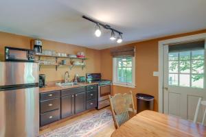 a kitchen with a stainless steel refrigerator and a table at Secluded Marshall Cottage Hot Tub and Mountain View in Marshall