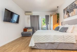 a bedroom with a bed and a flat screen tv at Apartmani Nikola in Baška Voda