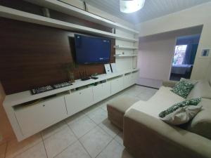 a living room with a couch and a large television at Casa 3quartos rota Maragogi Carneiros in São José da Coroa Grande