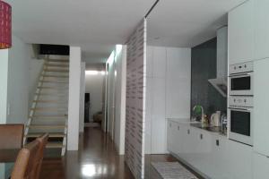a kitchen with white walls and a staircase in a room at Guerras House in Porto