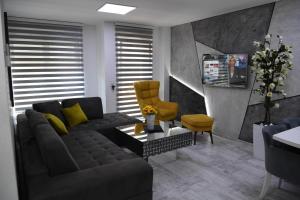 ein Wohnzimmer mit einem Sofa und einem gelben Stuhl in der Unterkunft RELAX LUX apartman in Jagodina