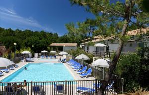 a pool at a resort with chairs and umbrellas at OSoleMio Moliets in Moliets-et-Maa