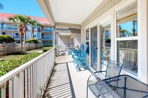 a balcony with blue chairs on a house at Sugar Sand Oasis in Santa Rosa Beach