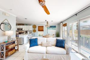 a living room with a white couch and blue pillows at Sugar Sand Oasis in Santa Rosa Beach