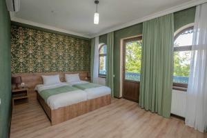 een slaapkamer met een bed en een groot raam bij Chateau Orberi in Ikalto