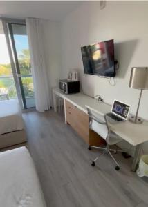 een kamer met een bureau en een laptop op een bureau bij Amplio Studio en hotel Beachwalk Resort Miami in Hallandale Beach