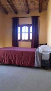 a bedroom with a large bed with a window at El Convento de Tilcara in Tilcara