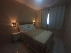 a small bedroom with a bed and a window at Casa 3quartos rota Maragogi Carneiros in São José da Coroa Grande