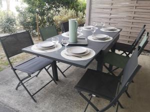 una mesa azul con sillas, platos y copas de vino en OSoleMio Moliets, en Moliets-et-Maa