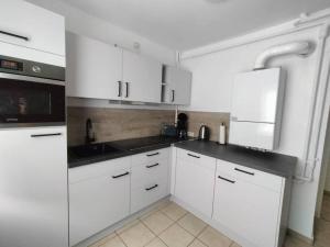 a white kitchen with white cabinets and a sink at Silbertaler in Bad Harzburg