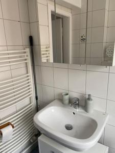 Baño blanco con lavabo y espejo en Silbertaler, en Bad Harzburg