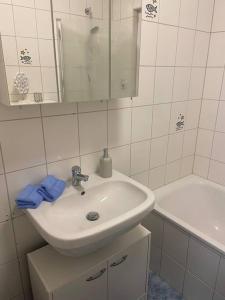Baño blanco con lavabo y bañera en Silbertaler, en Bad Harzburg