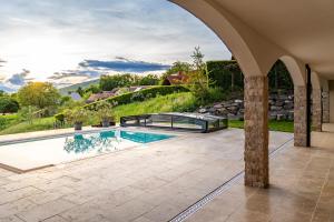a swimming pool in a yard with an archway at Urlaubsoase Hügelperle in Bad Gleichenberg