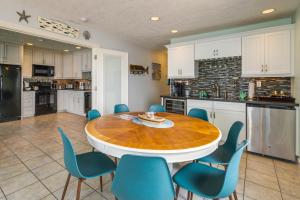 a kitchen with a wooden table and blue chairs at Prime Coastal Retreat on Lincoln City Beach! in Lincoln City