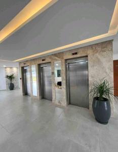a lobby with four elevators in a building at Kitnet à 300 metros da Canção Nova in Cachoeira Paulista