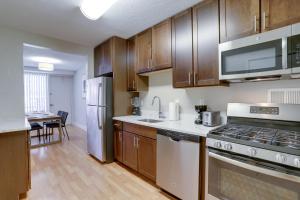 una cucina con armadietti in legno ed elettrodomestici in acciaio inossidabile di Spectacular Condo at Crystal CIty With Pool/Gym ad Arlington