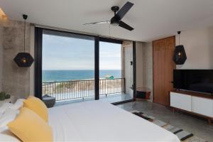 a bedroom with a large bed and a view of the ocean at Eolia Sustainable Design Hotel in Manta