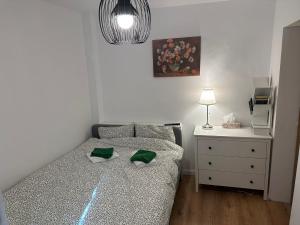 a bedroom with a bed and a dresser with a lamp at Tiny Traditional House in Bucharest