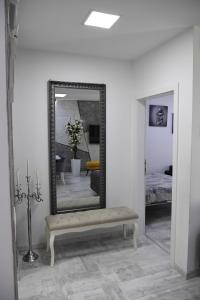 un miroir sur un mur avec un banc dans une pièce dans l'établissement RELAX LUX apartman, à Jagodina