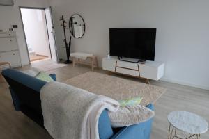 een woonkamer met een blauwe bank en een tv bij T3 Euro Beach Life - Salir do Porto in Salir de Porto