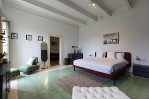 ein weißes Schlafzimmer mit einem Bett und einem Sofa in der Unterkunft Stylish Apartment steps from the Capital in Floriana