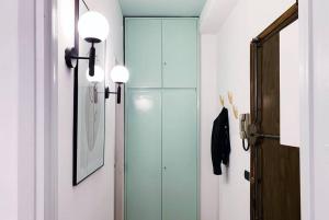 un pasillo con dos luces y una puerta de cristal en Monolocale comodo e funzionale sopra la metro Turro, en Milán