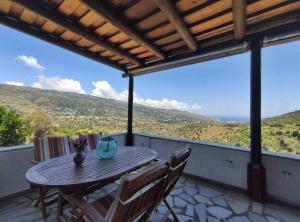 a table and chairs on a balcony with a view at Village Sense, Pergola & Unlimited View in Andros