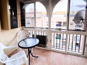 トレビエハにあるApartamento en Torreviejaのバルコニー(テーブル、椅子2脚、窓付)