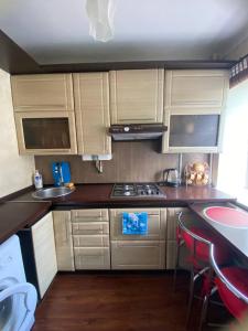 a kitchen with white cabinets and a stove top oven at Apartment in Shoduar's park in Zhytomyr