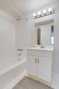 a white bathroom with a sink and a mirror at Spectacular 2/2 Apt @Crystal City With Gym in Arlington