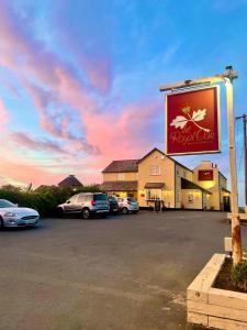 a sign for a restaurant with cars parked in a parking lot at Shepherds Gate at The Royal Oak Much Marcle in Preston