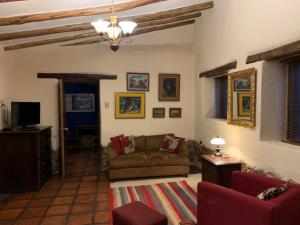 uma sala de estar com um sofá e uma televisão em Bungalows Perayoc em Urubamba