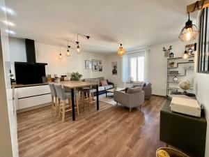a kitchen and living room with a table and chairs at L’Appart de Céline **** haut standing hypercentre in Gérardmer