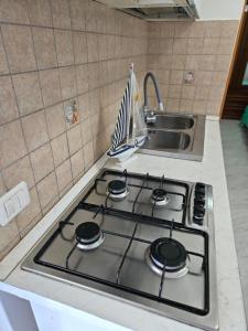 a stove top in a kitchen with a sink at Tuppo delle pile Seaview in Peschici