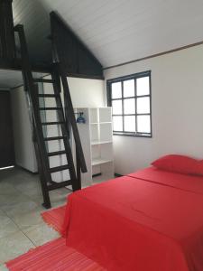 Un dormitorio con una cama roja y una escalera en FAKARAVA - Teariki Lodge 1 en Fakarava