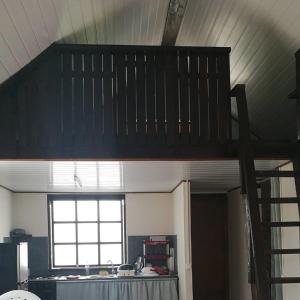 Cama elevada en habitación con ventana en FAKARAVA - Teariki Lodge 1 en Fakarava