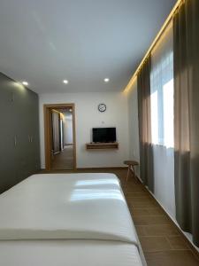 a bedroom with a large bed and a tv at Apartments Basha 1 - Long Beach in Ulcinj
