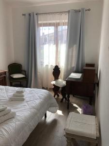 um quarto com uma cama e um piano ao lado de uma janela em Blumarine em Palau