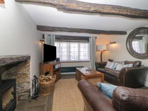 a living room with a couch and a fireplace at Alexandra Cottage in Looe