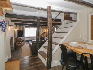 - un escalier en colimaçon dans un salon avec une table dans l'établissement Alexandra Cottage, à Looe