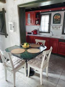 a kitchen with a table and chairs in a kitchen at Ktima Zotos luxury exotic cottage in Agria
