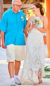 a bride and groom standing next to each other at Island Magic Beach Resort in Caye Caulker