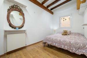 ein Schlafzimmer mit einem Bett und einem Spiegel an der Wand in der Unterkunft Voramar in Torredembarra
