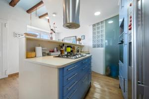 a kitchen with blue cabinets and a blue and white counter top at Voramar in Torredembarra +15 photos